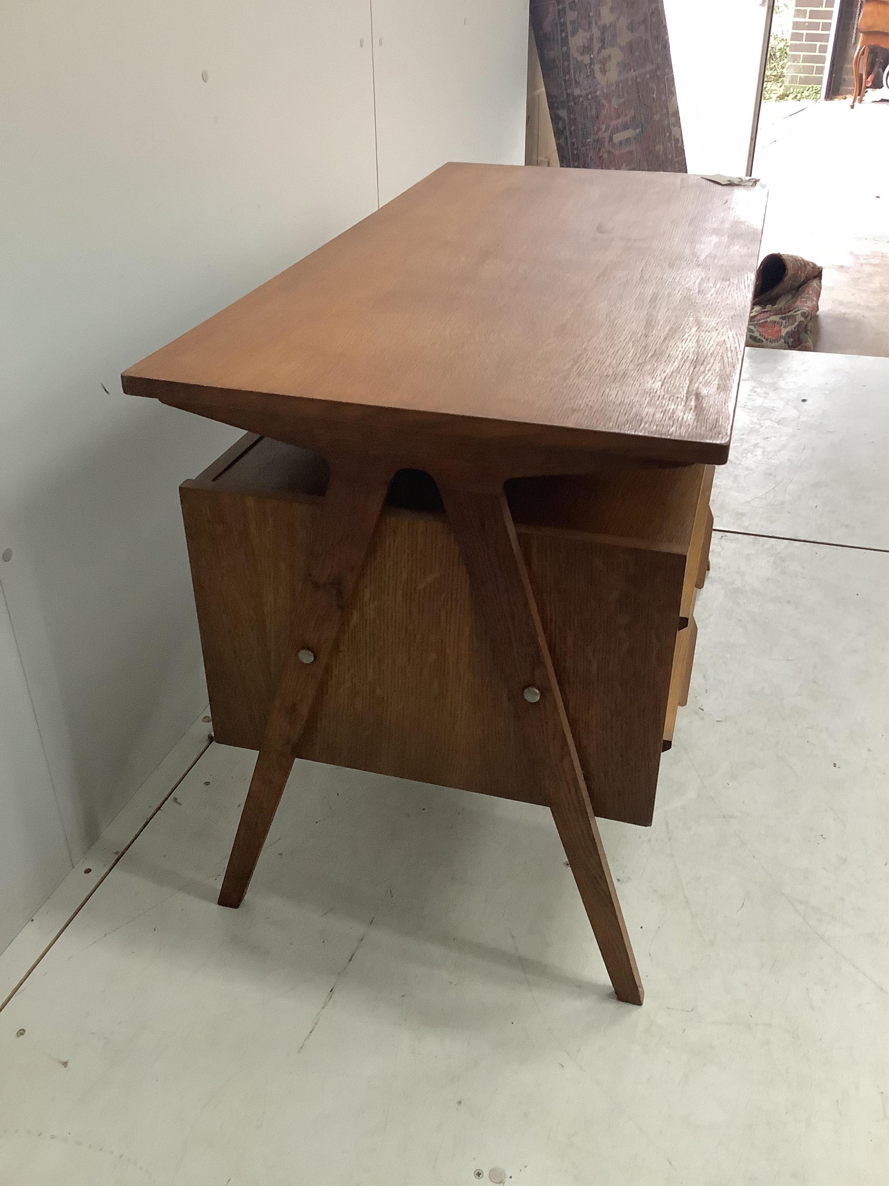 In the manner of Robin Day, a 'Hillstak' type oak desk, width 110cm, depth 55cm, height 71cm. Condition - fair